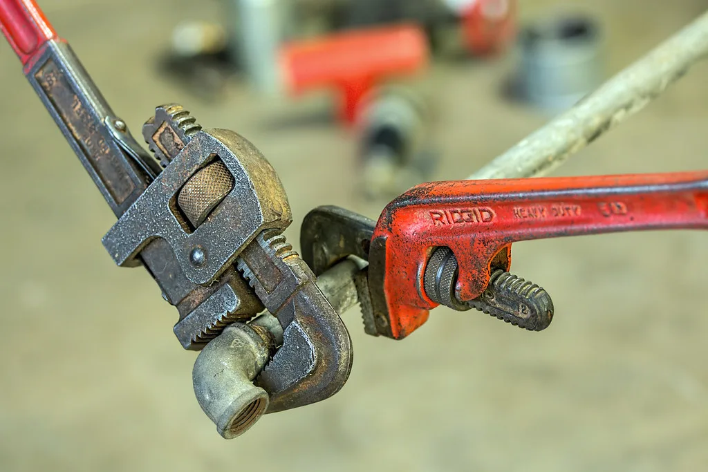 Plumber using a pipe wrench on a repair